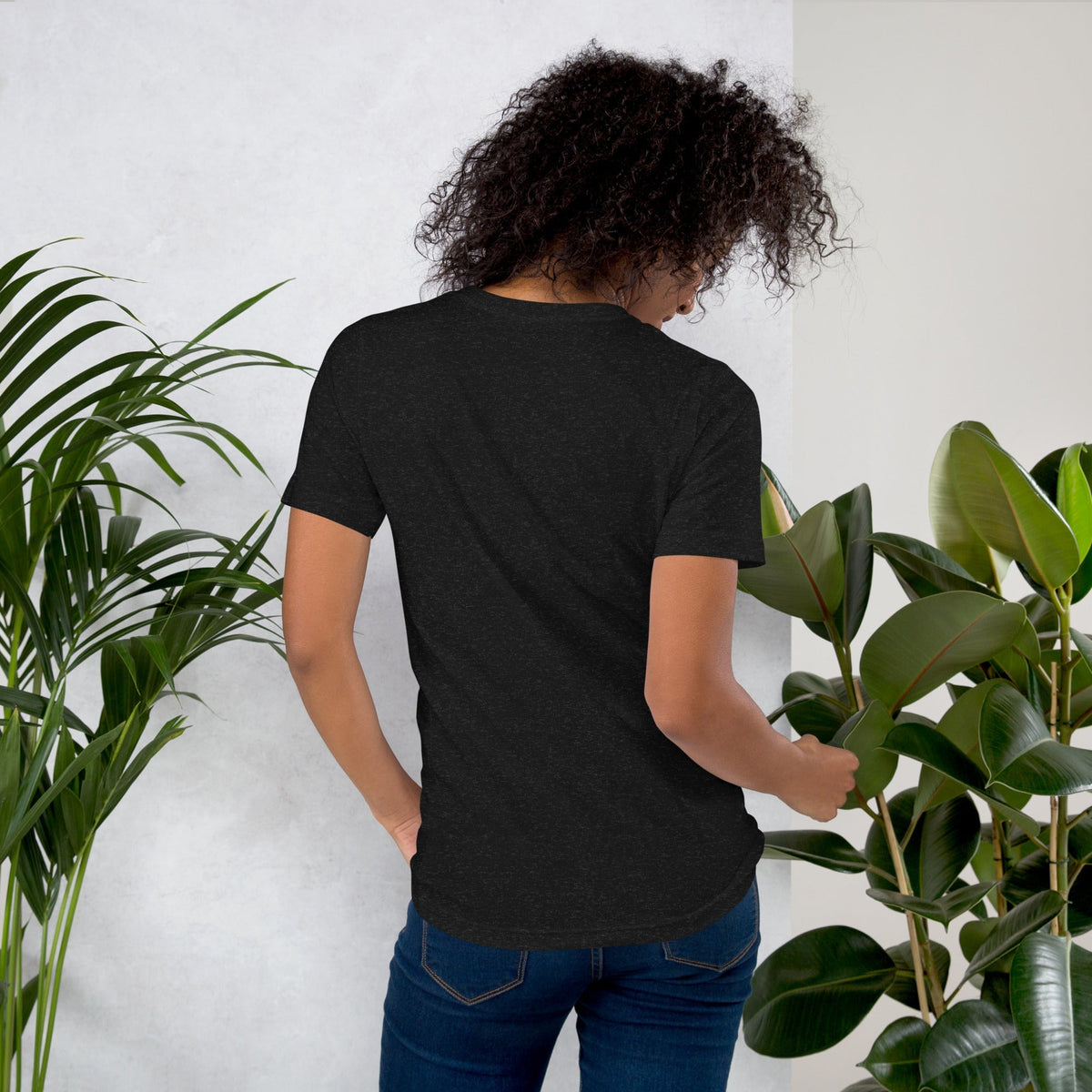 Woman wearing a WORTHY affirmation t-shirt surrounded by plants – positive fashion wardrobe by Power of Positivity